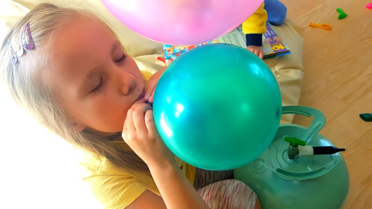 Дети надувают шарики с гелием