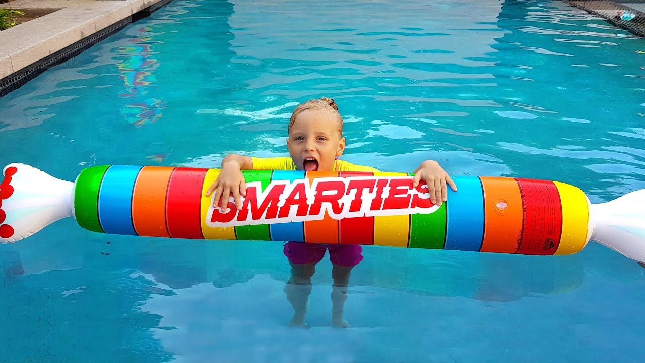 Children Pretend Play with Giant Inflatable Toys & swimming in the pool