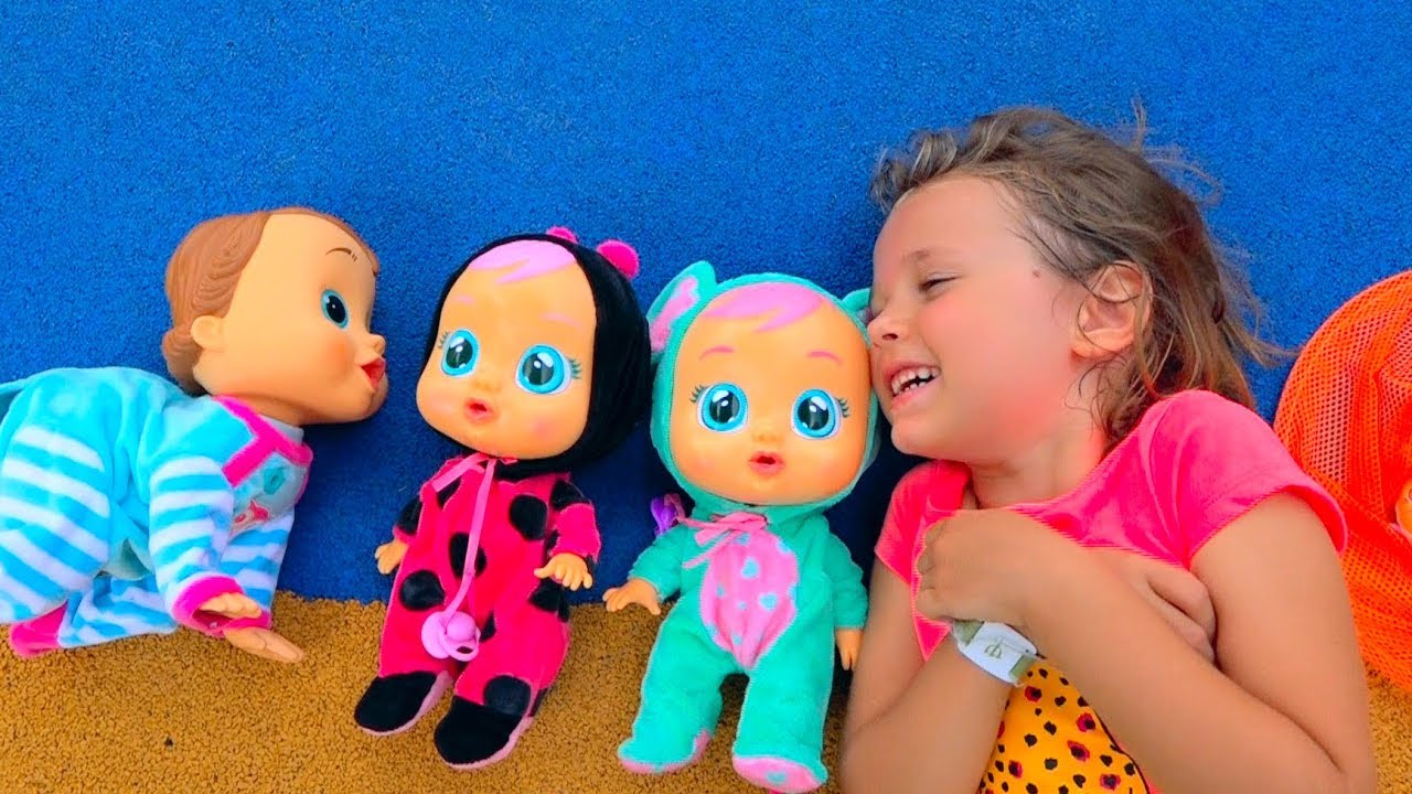 Катя играет с куклами на детской площадке и ловит бабочек